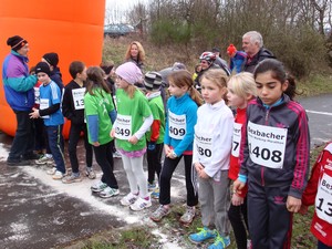 Kinder stehen an einer Startlinie auf einem aspahltierten Feldweg, bereit, jeden Augenblick loszulaufen