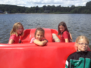 4 Kinder in einem roten Tretboot mitten auf dem Bostalsee