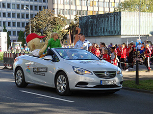 Elisabeth Seitz (deutsche Kunstturnerin) fährt zusammen mit dem Maskottchen vor dem Umzug her, beide sitzen in einem Opel (Sponsor) Cabriolet